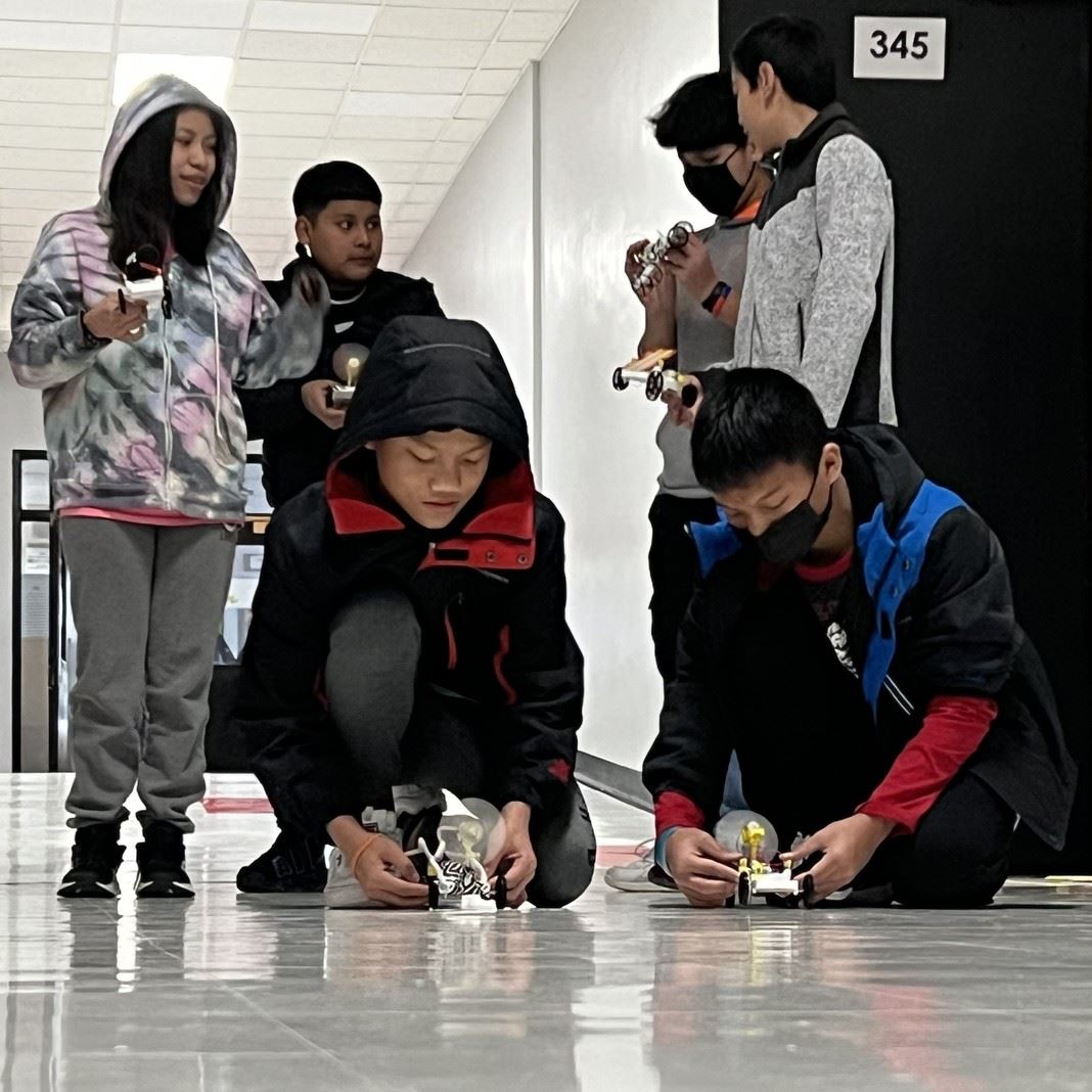  Students race cars in a hallway